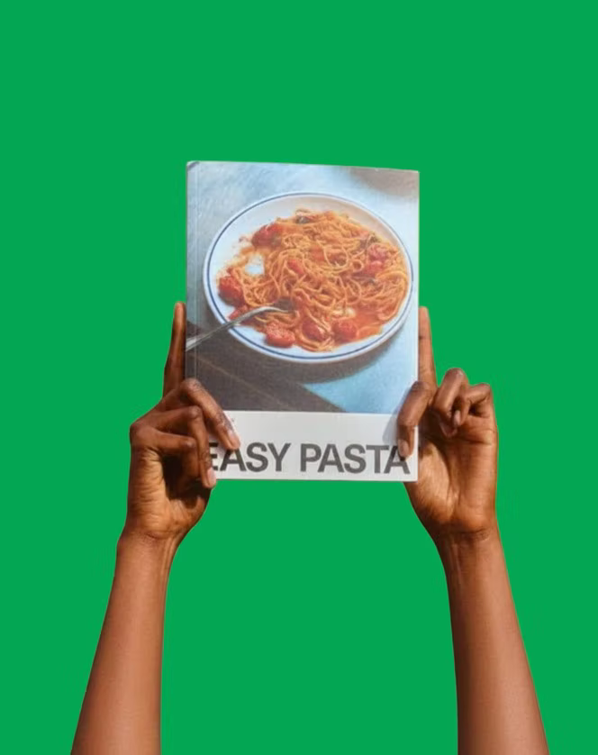 Easy Pasta held up against an Italian green wall